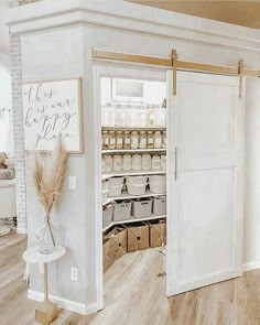 an open pantry door in the middle of a room with white walls and wood floors