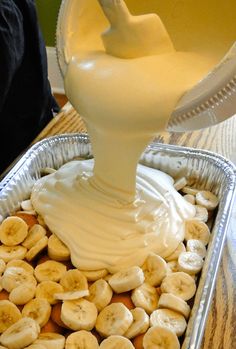 a pan filled with bananas and cream being poured into the battershake in it