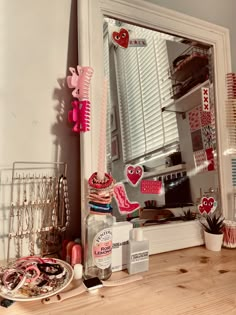 a mirror sitting on top of a wooden table next to a shelf filled with jewelry