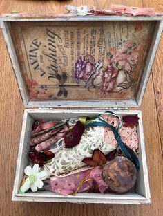 an open box filled with assorted items on top of a wooden table