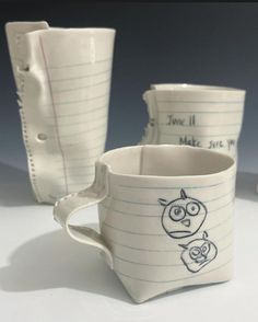 three mugs with writing on them sitting next to each other