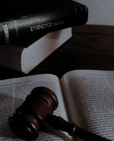 a judge's gaven sitting on top of an open book next to a law book