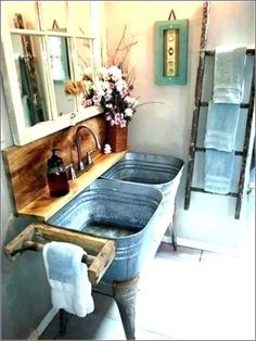 a bathroom with two sinks and towels on the rack in front of the sink is a ladder