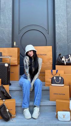 a woman sitting on the steps with many bags and purses in front of her