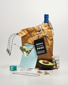 an avocado, notepad, and bottle of alcohol sitting on a table