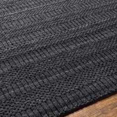 a black rug on top of a wooden floor