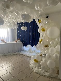 a room decorated with white and gold balloons