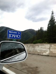 there is a sign that says welcome to idaho on the back of a car's side view mirror