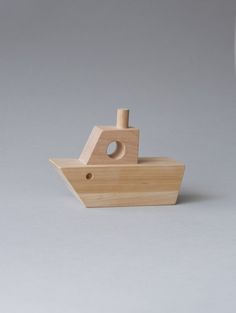 a wooden toy boat on a white surface