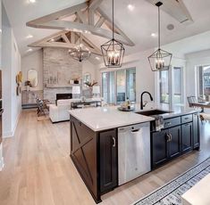 a large kitchen with an island in the middle and lots of lights hanging from the ceiling