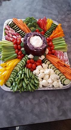 a platter filled with vegetables and dip