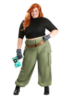 a woman with red hair wearing green pants and black top, holding a cell phone