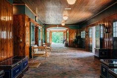 an empty room with wood paneling and brick floors