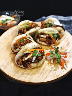 some tacos with meat and vegetables on a wooden platter, ready to be eaten