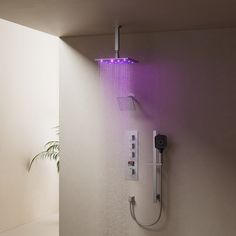 there is a shower head with purple light coming from it and a plant in the corner