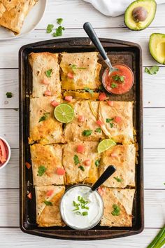 an overhead view of mexican food on a tray with salsa and guacamole