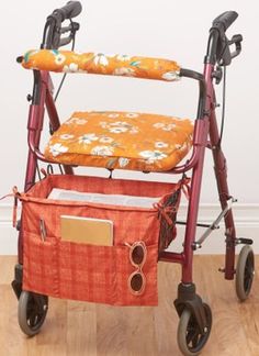 a red walker with an orange flowered seat cover on it's back and wheels