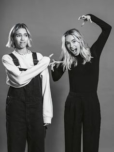 two women standing next to each other in black and white