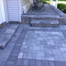 an outdoor patio with steps leading up to the front door and back porch area that is made out of pavers