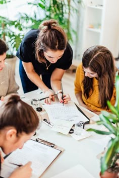 a group of people sitting around a table with papers and pencils on top of it