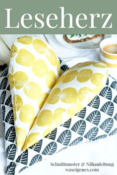 a heart shaped pillow sitting on top of a bed next to a cup and saucer