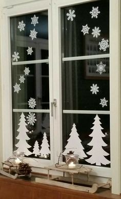 a window decorated with snowflakes and christmas trees