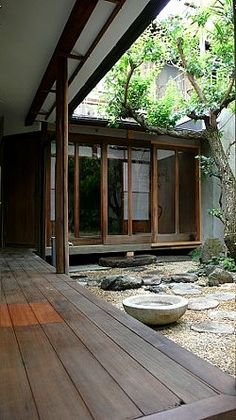 an outdoor area with rocks and trees in the center, surrounded by wooden decking