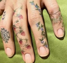 a woman's hand with tattoos on her left and the other half of her fingers