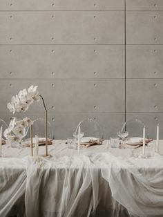 the table is set up with white flowers and candles for an elegant wedding breakfasteon