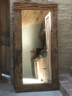 a mirror that is in the middle of a room with a brick floor and walls