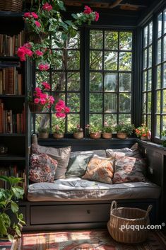 a window seat with flowers hanging from it's sides and bookshelves in the background