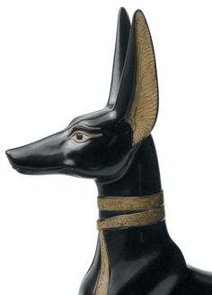 an egyptian style dog figurine in black with gold trimmings on its neck