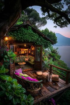 an outdoor living area with potted plants and flowers on the deck next to water