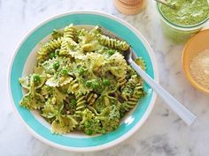 a bowl filled with broccoli sitting on top of a table next to a cup