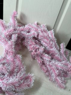 a pink and white scarf laying on top of a door