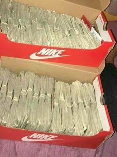 two boxes filled with money sitting on top of a bed