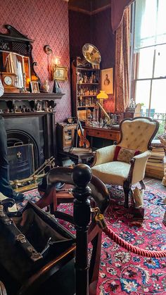 a living room filled with furniture and a fire place next to a large window on top of a rug