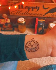 a person's arm with a tattoo that has a jack - o - lantern on it