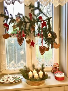 a window sill filled with christmas decorations and cookies next to a plate of cookies