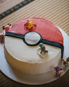 a pokemon cake is decorated with figurines and frosting