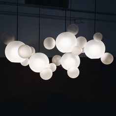 a group of lights hanging from the ceiling in a dark room with no one around them