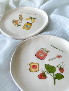 two plates with designs on them sitting on a bed