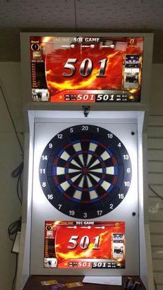 an electronic dart board mounted to the side of a wall