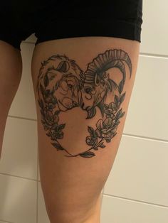 a woman's thigh with two rams in the shape of a heart on it