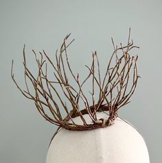 a white mannequin head with branches on it