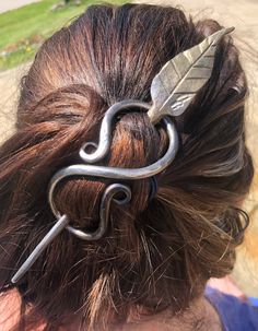 a close up of a person wearing a hair clip with an arrow on it's back