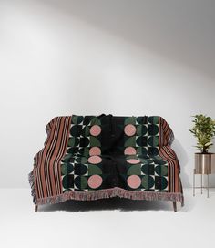 a couch sitting next to a potted plant on top of a table