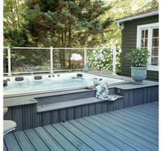 a large hot tub sitting on top of a wooden deck