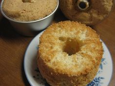 two donuts sitting on top of a white plate next to a bowl of doughnuts