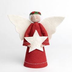 a red angel with white wings and a star on its back is standing in front of a white background